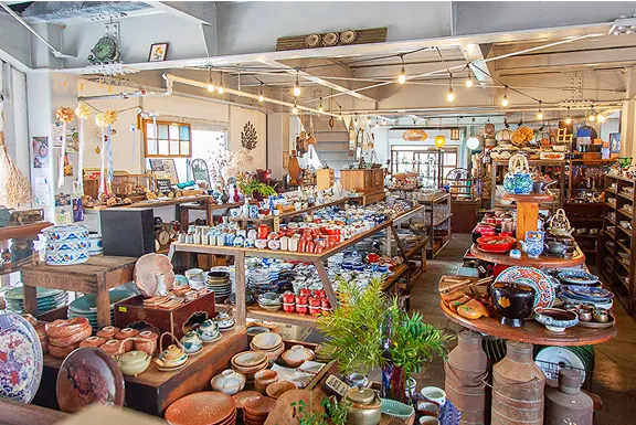 たくさんの陶器が並ぶ店の内部。棚やテーブルの上にお皿や茶碗、急須などが陳列されている。