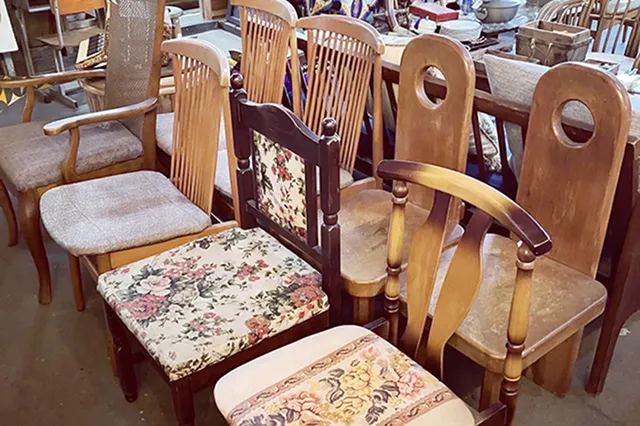 形や座面の布地が異なる、たくさんの木製椅子が所狭しと並んでいる様子。